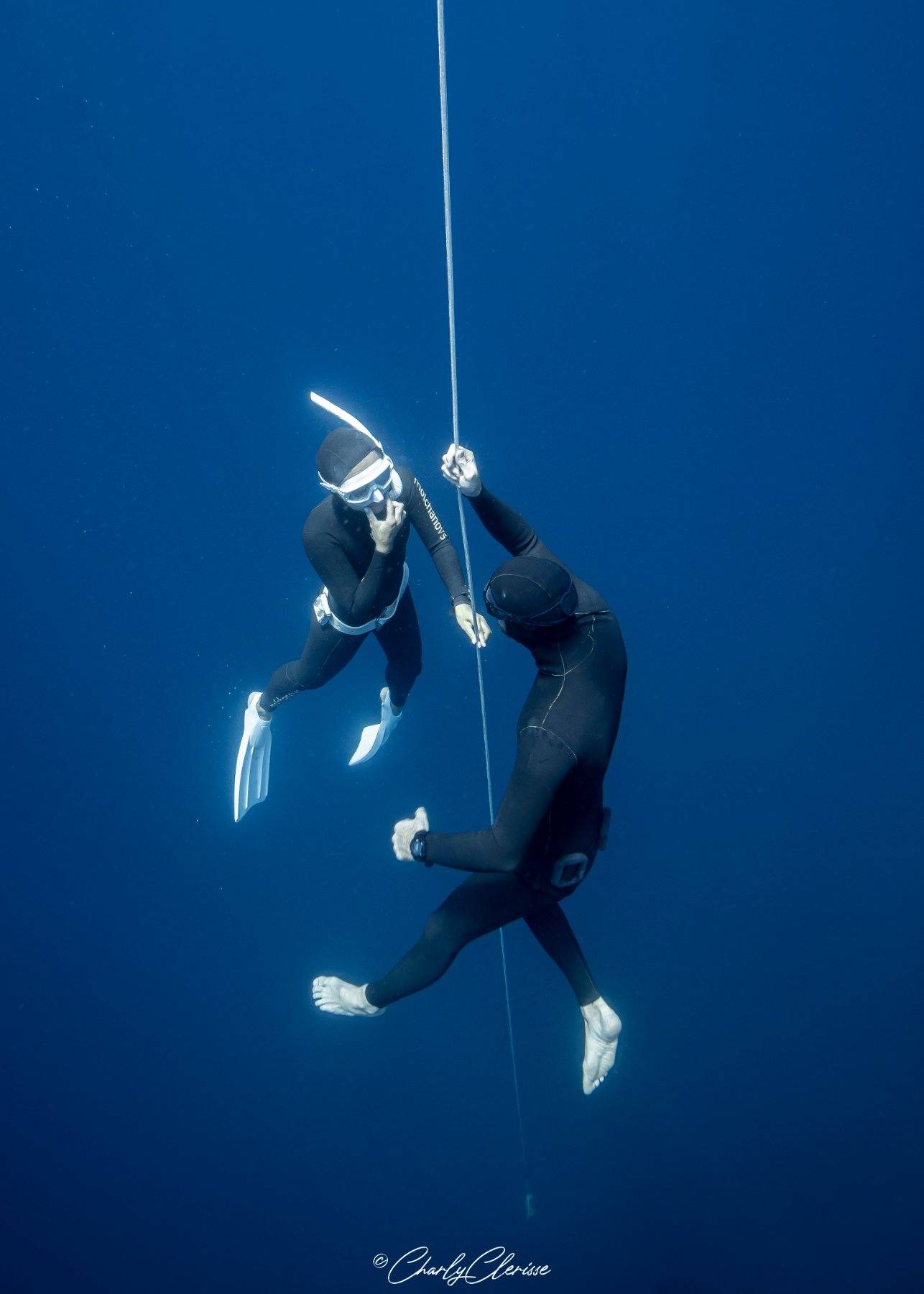 A coach beside a student on the line in deep blue water, guiding her equalisation