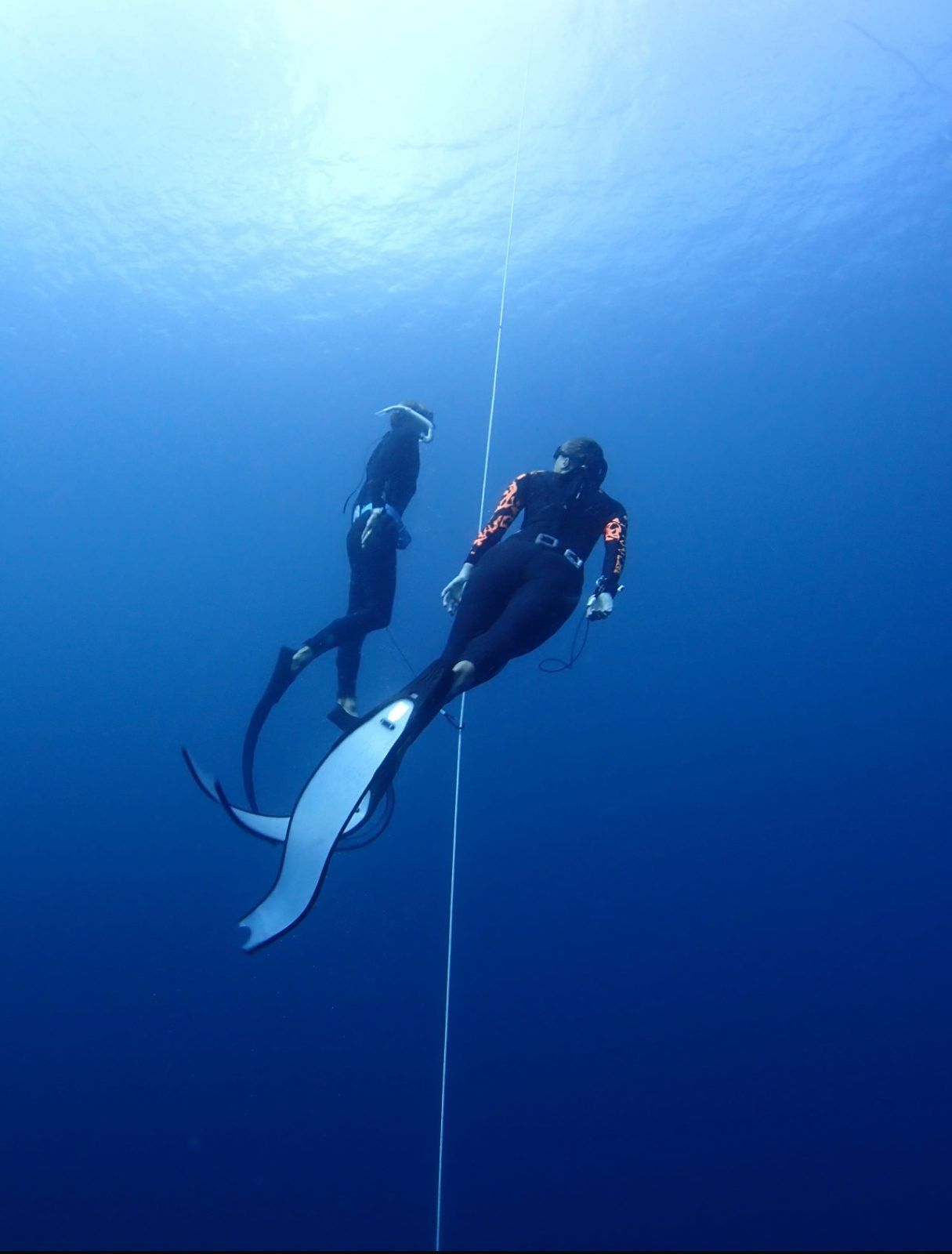 A coach diving alongside a student on the line