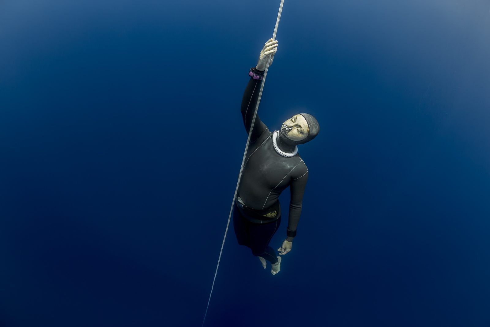 A freediver ascending the line from deep blue water